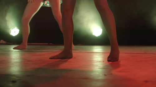 Slow motion low angle shot of a group of dancers' feet moving on a stage