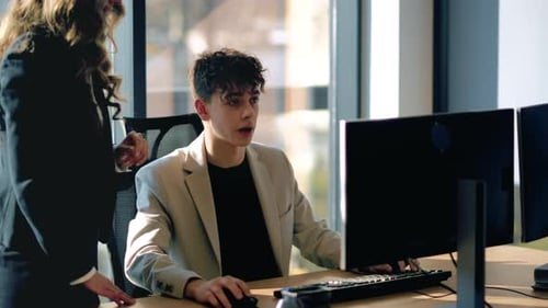 Young Adult Working on Computer With Team Member