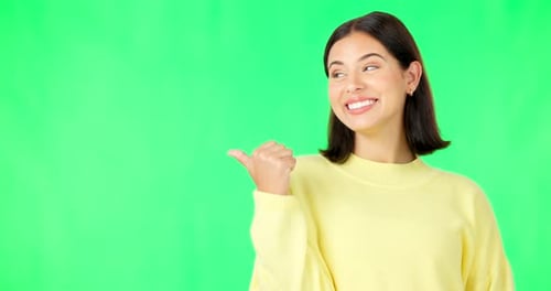 Portrait, pointing and branding with a woman on green screen space in studio for marketing
