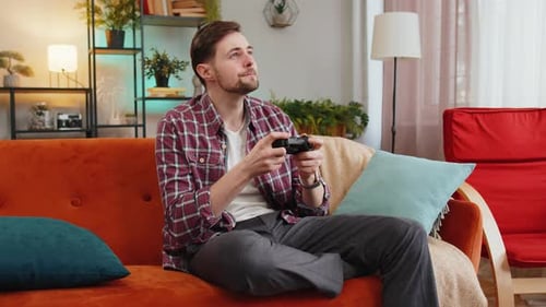 Excited Man Playing Video Game at Home