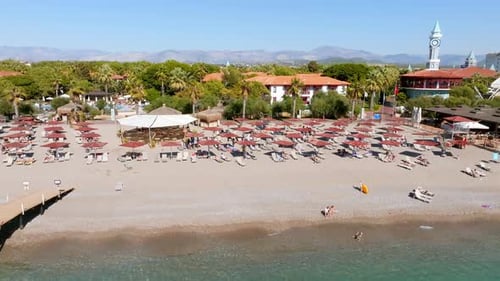 Aerial View of Umbrellas Palms on the Sandy Beach People Blue Sea with Waves at Sunset