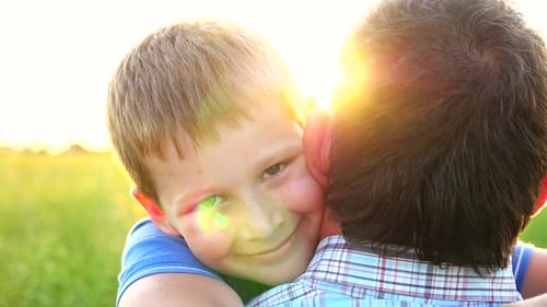 Boy Hugs Adult in Golden Field