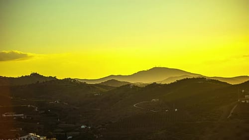 A Time Lapse Of A Sunrise Forming A Yellow Sky And A Mountainscape In Spain
