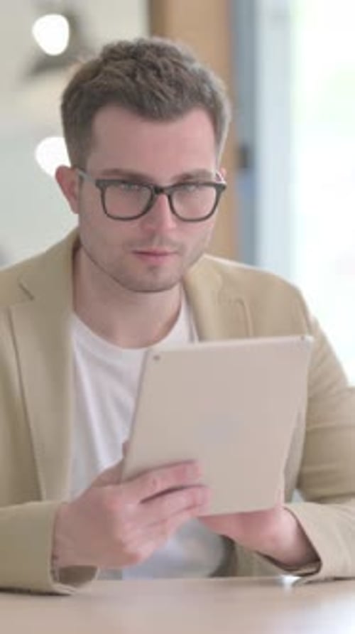 Excited Man Celebrates Success Using a Tablet