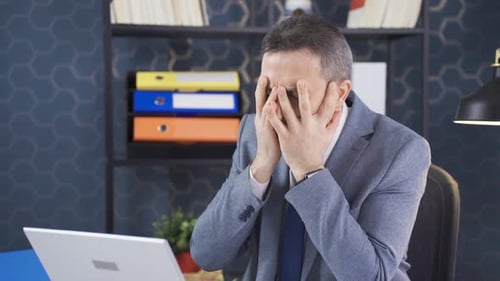 Man Feeling Frustrated While Working at Desk