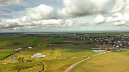 Aerial View Of Serene Rural Farmland With White Clouds Overhead. Push Forward Shot