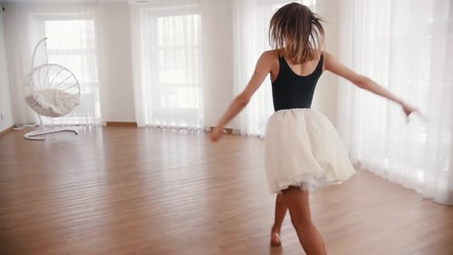 Woman in Tutu Dancing in Light Studio