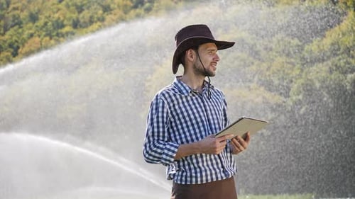 Farmer Using Digital Tablet During Monitoring His Plantation