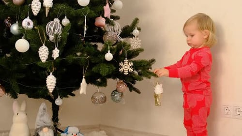 Little Girl Decorating Christmas Tree with Baubles