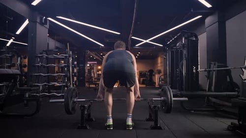 Muscular Athletic Man Workout Doing Deadlift Exercise with Heavy Weight Barbell in Gym - slow motion