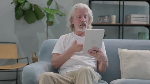 Senior Man Video Calling on Tablet at Home