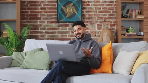 Man Talking on Laptop Video Call from Home