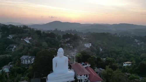 Drone photo d'un grand Bouddha blanc assis surplombant les collines verdoyantes environnantes
