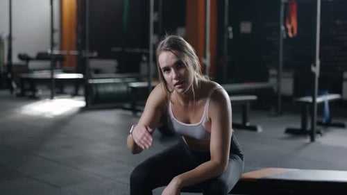 Young Pretty Woman Resting After a Workout in Gym Fatigue After Exercise