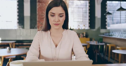 4k video footage of an attractive young woman using a laptop in a coffee shop