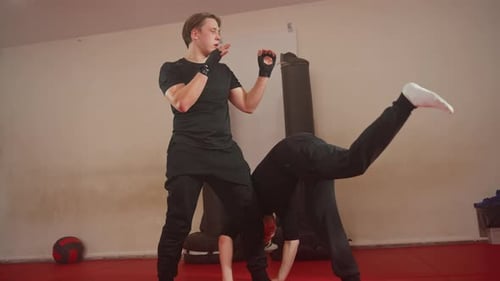 Boxer Practicing Martial Arts Sparring with Partner in Gym Wearing Black