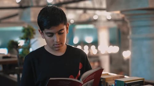 Porträt eines Jungen, der sich auf das Lesen eines Buches konzentriert