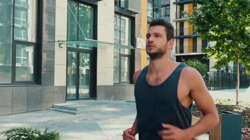 Man Jogging on Paved Path in Urban Setting