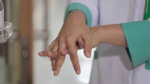 Healthcare Worker Using Hand Sanitizer in Hospital