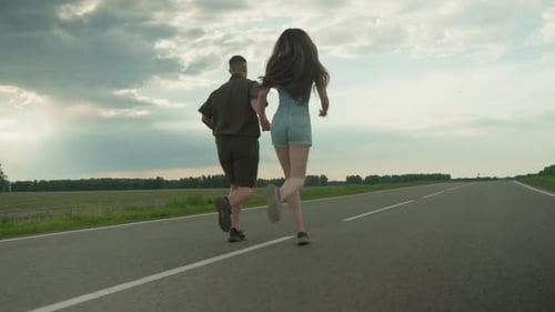 Couple Running Hand in Hand on Open Country Road