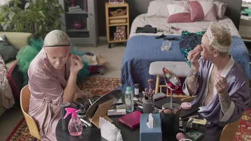 Hombres queer maquillándose y charlando en casa