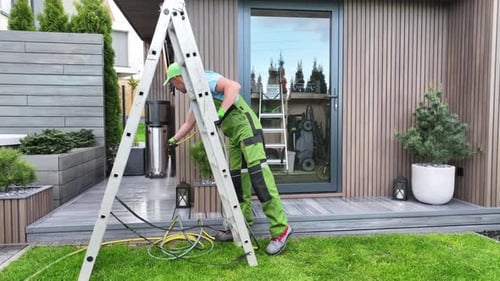 Man Power Washing Wood Deck in Suburban Yard