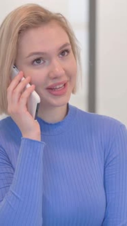 Young Woman Talking on Cellphone in Bright Indoor Setting