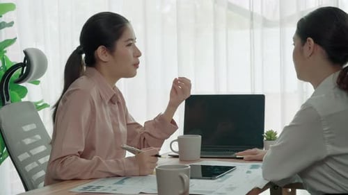 Two Young Enthusiastic Businesswoman Working Together in the Office Workspace