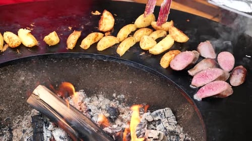 Cooking potatoes and sausages on an open fire