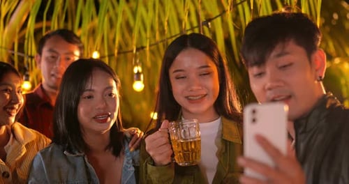 Friends Enjoying Night Out with Drinks and Technology