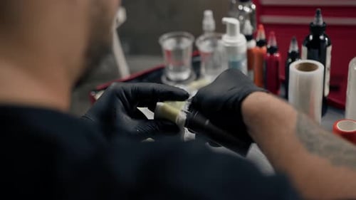 Tattoo Artist Prepping Tattoo Machine with Sterile Bandage