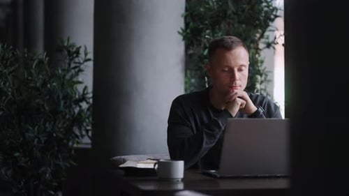 Businessman With Laptop Sitting In Cafe And Working Online Monitoring Cryptocurrency Rate Portrait