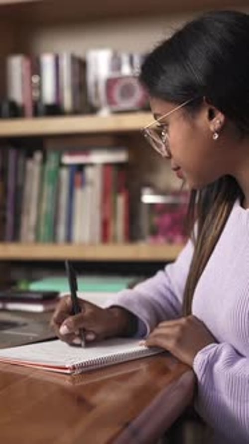 Woman Attends an Online Meeting and Writes Notes