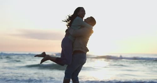 Happy, sunset and a couple with a hug at the beach for love, a date or romance together on holiday