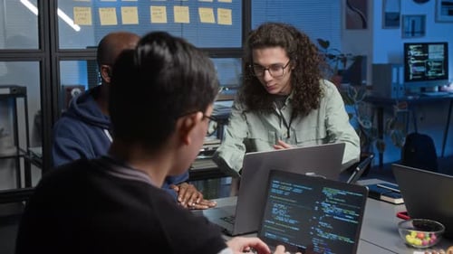 Diverse Team of Young Programmers Designing Software in Dimly Lit IT Office