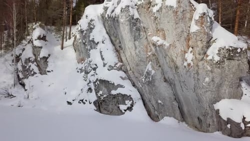 Snowy Rock Formation Surrounded by Winter Forest