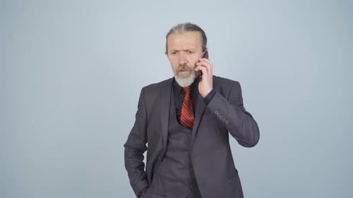 Upset Man in Suit Talks on Phone