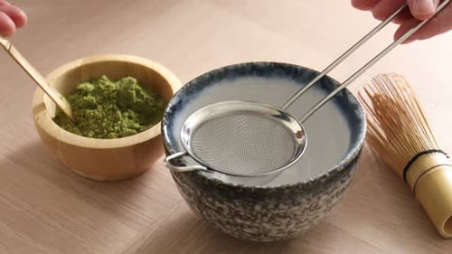 Preparing Matcha Tea with Wooden Bowl and Whisk