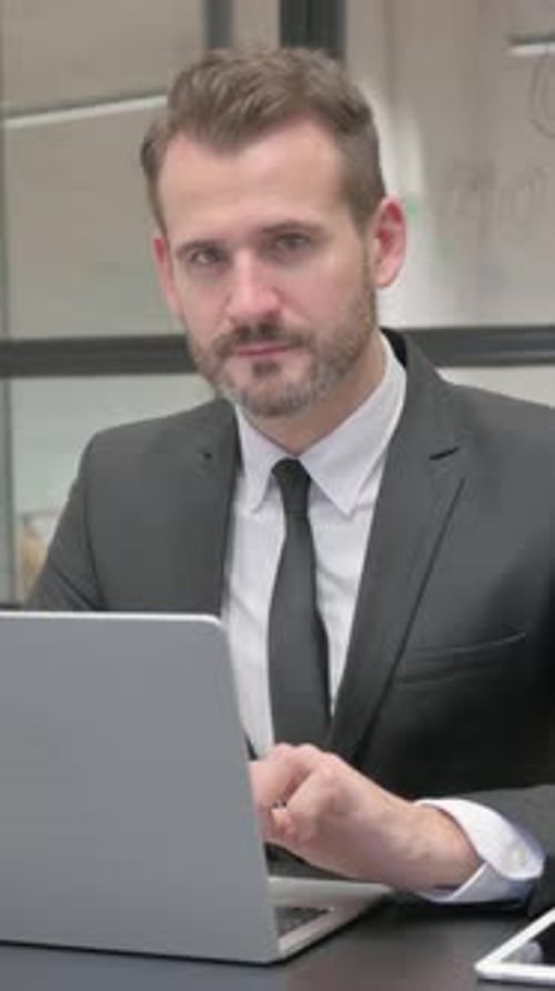 Man in Suit Using Laptop and Smiling