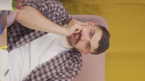 Vertical video of Man looking thoughtfully at camera.