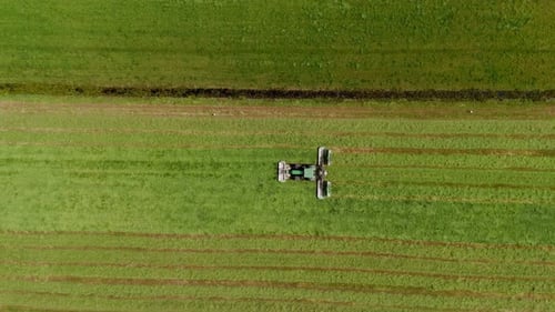 Tracteur tondant et récoltant de l'herbe dans une grande prairie, Frise, Pays-Bas