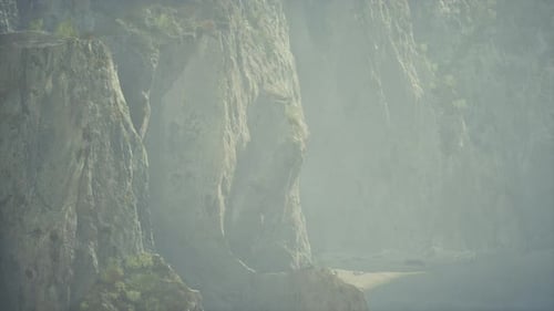Un paisaje montañoso brumoso con un cuerpo de agua sereno