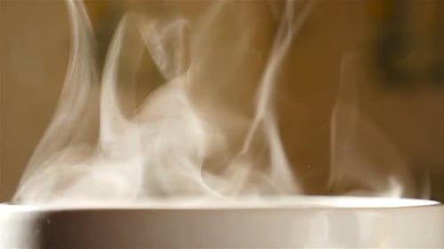 Transparent steam in a cup with tea. Slow-motion. Close-up