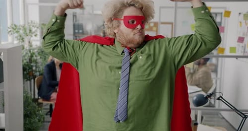 Employé de bureau potelé en costume de super héros montrant des muscles debout au travail