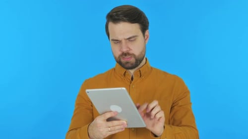 Man Using Tablet Against Blue Background