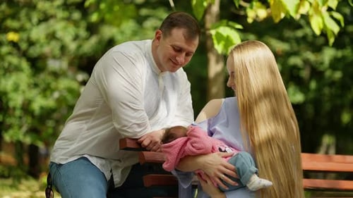 Happy Parents with Newborn Baby in the Park Concept of Parents with Baby