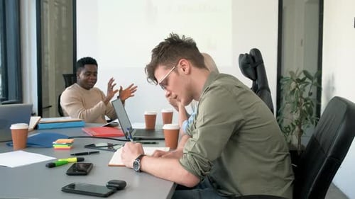 Diverse group of young people working on new project together in office.