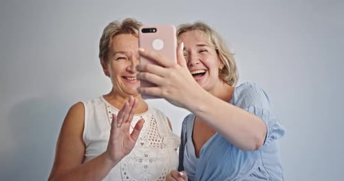 Women Video Calling on Phone in Home Setting