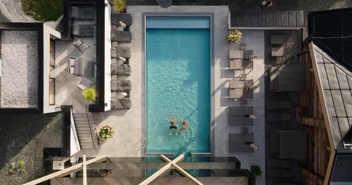 Overhead Shot Of Couple Enjoying Sunlit Pool
