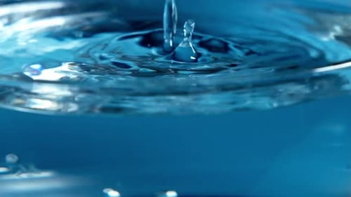 Macro Shot of Water Being Poured into Container